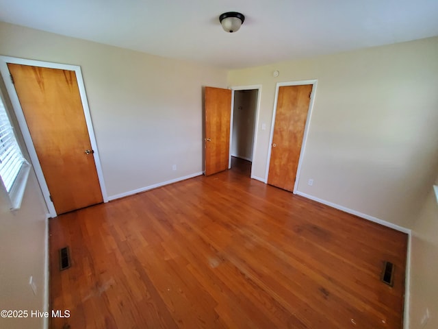 2703 Langston Dr, Goldsboro, NC 27534 - unfurnished bedroom featuring visible vents, wood finished floors, and baseboards