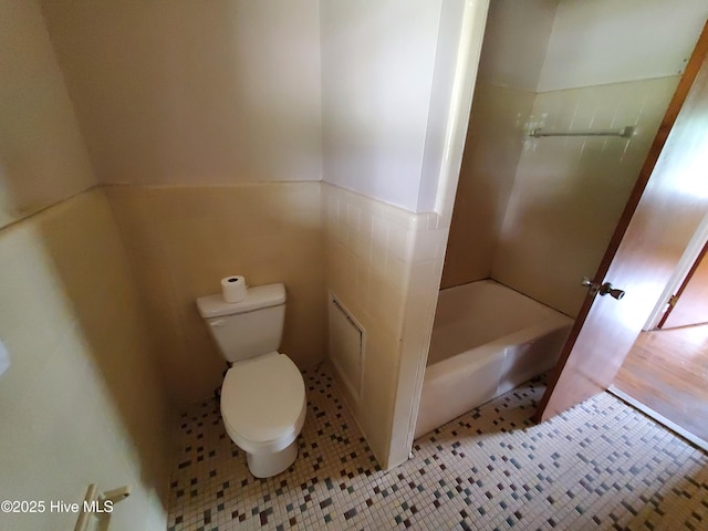 2703 Langston Dr, Goldsboro, NC 27534 - full bath featuring toilet, shower / washtub combination, a wainscoted wall, and tile patterned floors