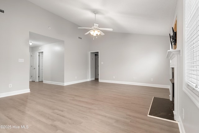 315 Whirlaway Blvd, Sneads Ferry, NC 28460 - unfurnished living room featuring a ceiling fan, a fireplace with flush hearth, light wood-type flooring, baseboards, and high vaulted ceiling