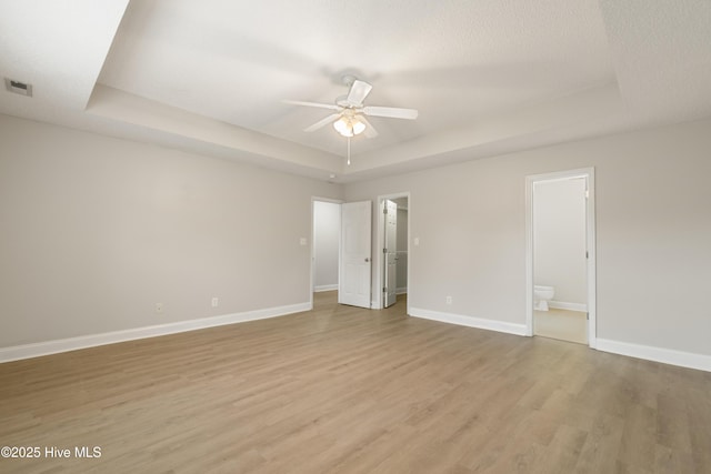 315 Whirlaway Blvd, Sneads Ferry, NC 28460 - unfurnished bedroom with a raised ceiling, light wood-style flooring, baseboards, and ensuite bathroom