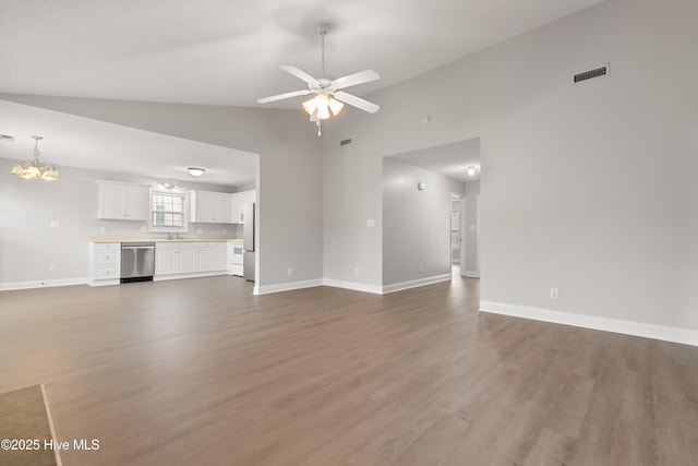 315 Whirlaway Blvd, Sneads Ferry, NC 28460 - unfurnished living room featuring wood finished floors, a ceiling fan, baseboards, a chandelier, and high vaulted ceiling