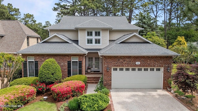 view of front of home with concrete driveway, an attached garage, brick siding, and a shingled roof