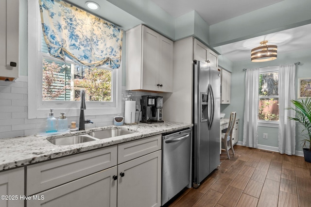 kitchen with a sink, appliances with stainless steel finishes, backsplash, and white cabinets