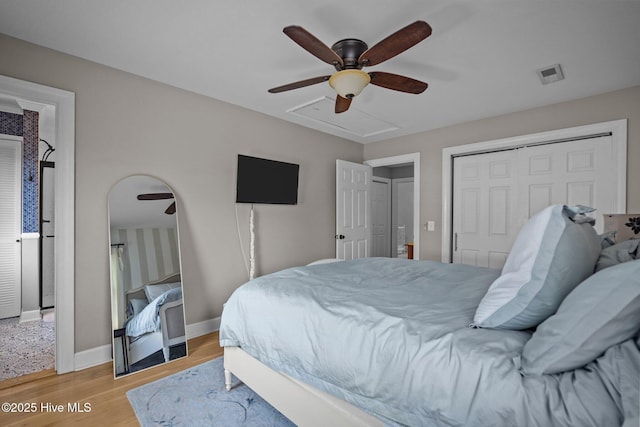 bedroom featuring ceiling fan, visible vents, baseboards, a closet, and light wood finished floors
