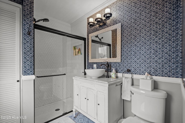 full bathroom featuring crown molding, vanity, toilet, wallpapered walls, and a stall shower