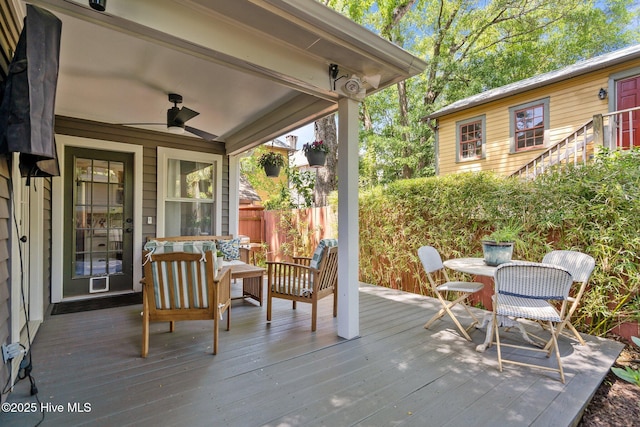 wooden terrace with ceiling fan and fence