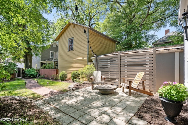 view of patio with fence and a fire pit