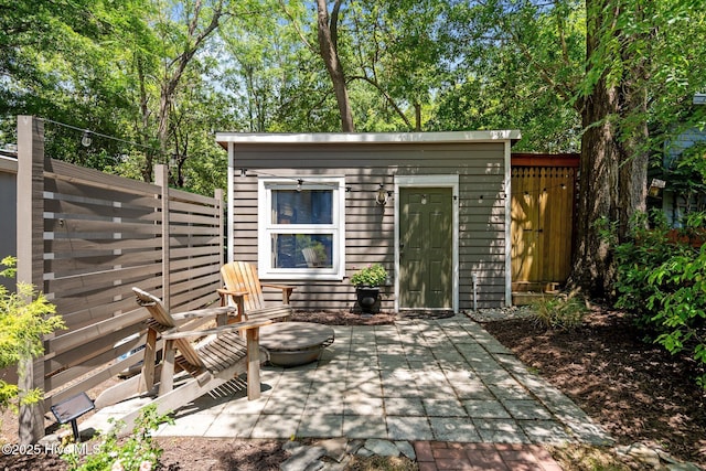 view of patio / terrace featuring fence and an outbuilding