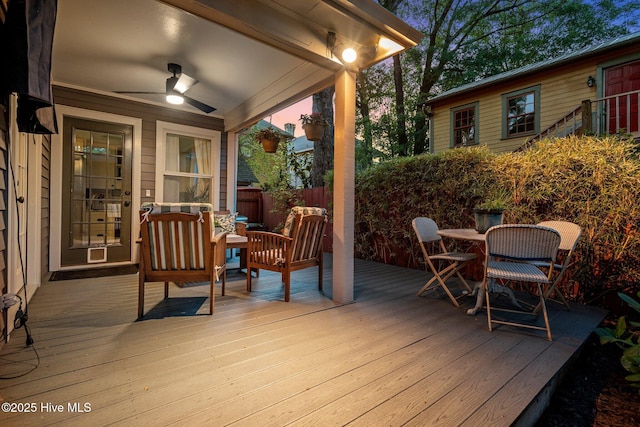 wooden deck with ceiling fan and fence