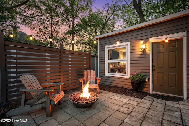 patio terrace at dusk with fence and a fire pit