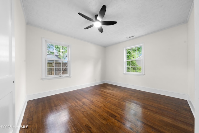unfurnished room with a textured ceiling, visible vents, baseboards, a ceiling fan, and wood finished floors
