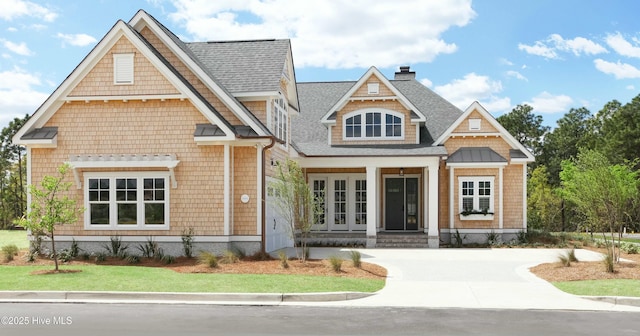 view of front of property with roof with shingles and a chimney