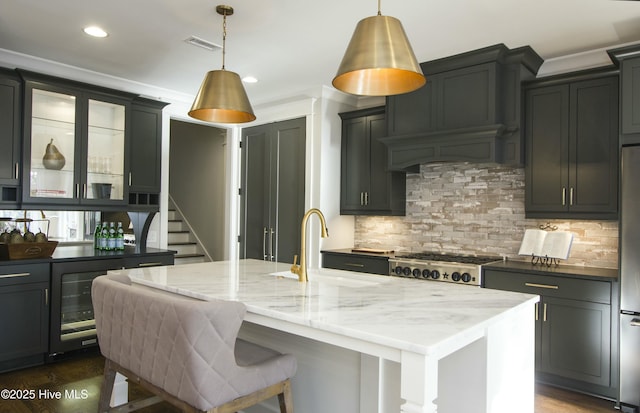 kitchen with light stone countertops, decorative backsplash, beverage cooler, and a sink