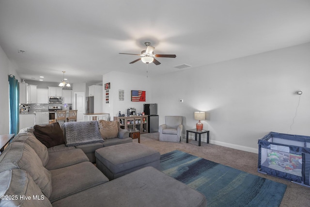 carpeted living area with ceiling fan, visible vents, and baseboards