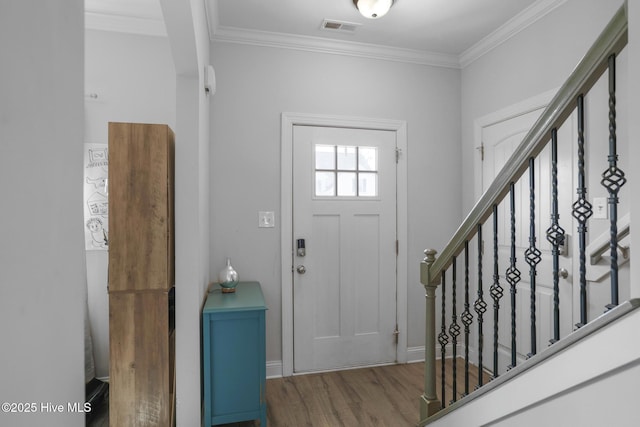 entrance foyer featuring visible vents, wood finished floors, stairway, baseboards, and ornamental molding