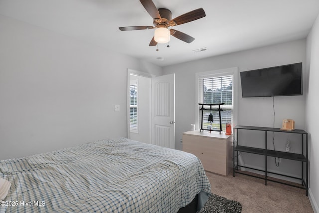 carpeted bedroom featuring visible vents, a ceiling fan, and baseboards