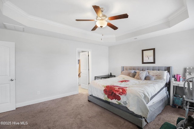 carpeted bedroom featuring ceiling fan, visible vents, baseboards, ornamental molding, and a tray ceiling