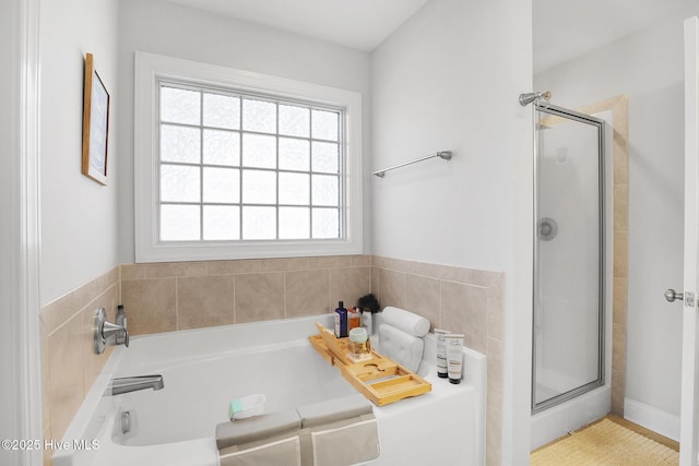 full bathroom with a bath and a shower stall