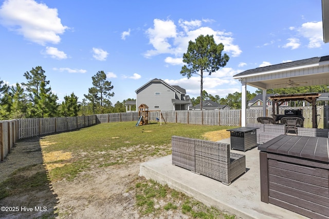 view of yard featuring a patio area, a ceiling fan, a playground, and a fenced backyard