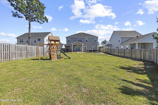 view of yard with a fenced backyard, a playground, and a residential view