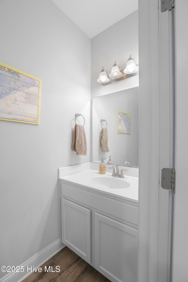 bathroom with baseboards, wood finished floors, and vanity
