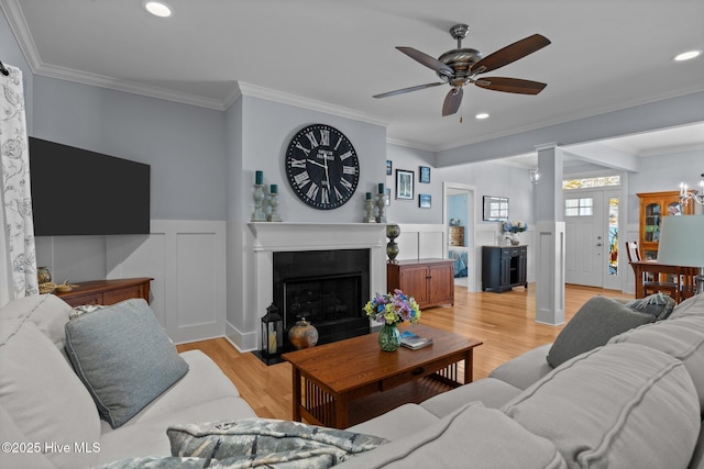 2312 Caracara Dr, New Bern, NC 28560 - living room featuring a ceiling fan, a fireplace with flush hearth, light wood finished floors, ornamental molding, and recessed lighting
