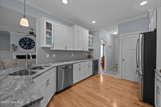 2312 Caracara Dr, New Bern, NC 28560 - kitchen featuring appliances with stainless steel finishes, a sink, crown molding, wine cooler, and white cabinets
