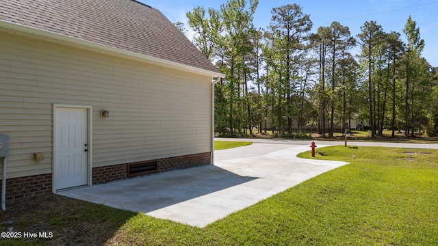 2312 Caracara Dr, New Bern, NC 28560 - view of side of property with a yard, roof with shingles, a patio, and concrete driveway
