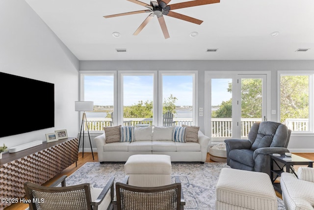 living room with ceiling fan, visible vents, and wood finished floors