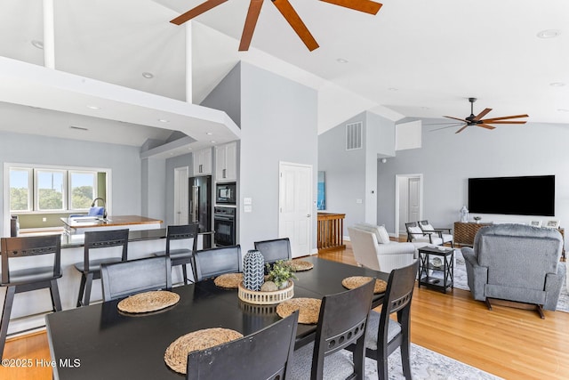 dining area featuring a ceiling fan, visible vents, high vaulted ceiling, light wood finished floors, and recessed lighting