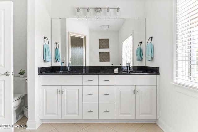 full bathroom with double vanity, a sink, baseboards, and toilet