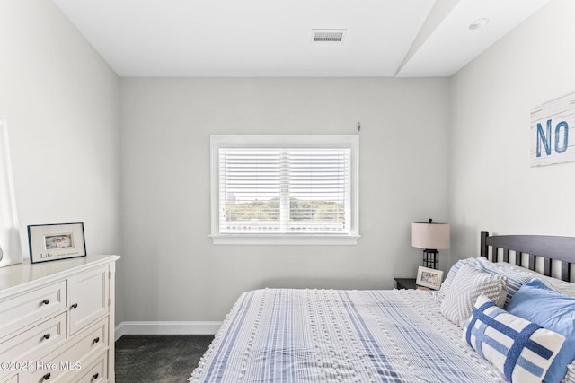 bedroom with baseboards, visible vents, and dark carpet