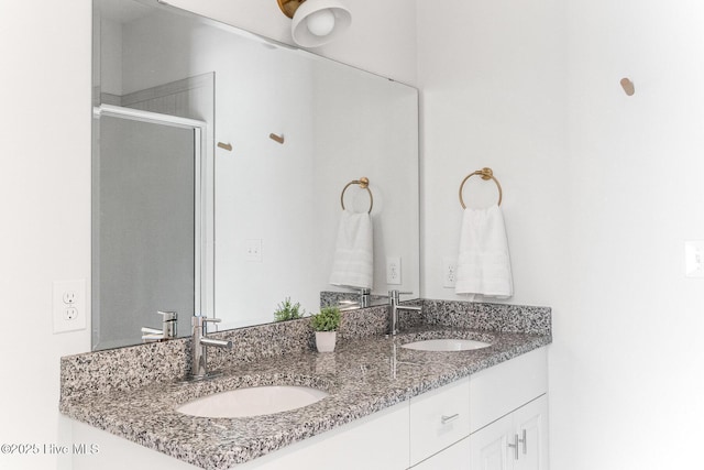 bathroom featuring double vanity, a sink, and an enclosed shower