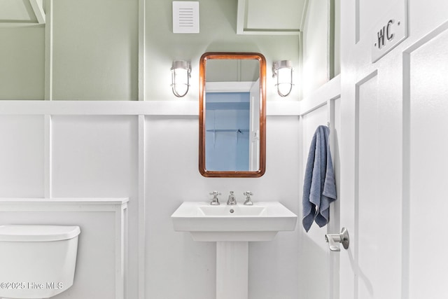 half bathroom featuring toilet and visible vents
