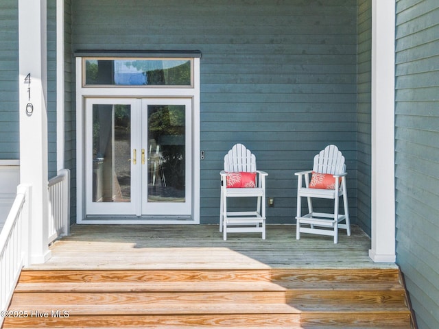 view of exterior entry featuring french doors and a deck