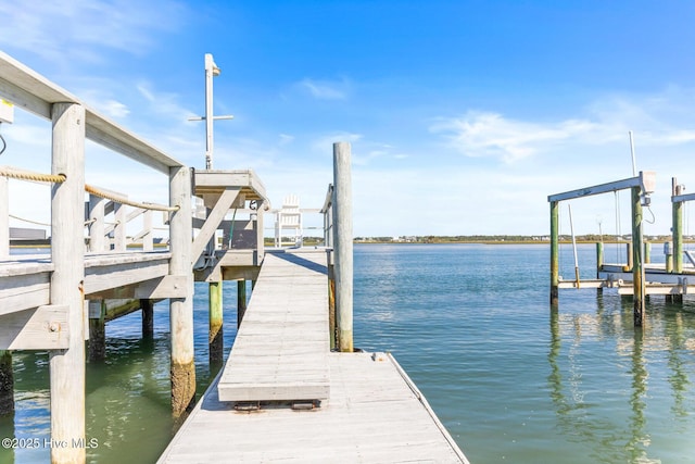 view of dock with boat lift and a water view