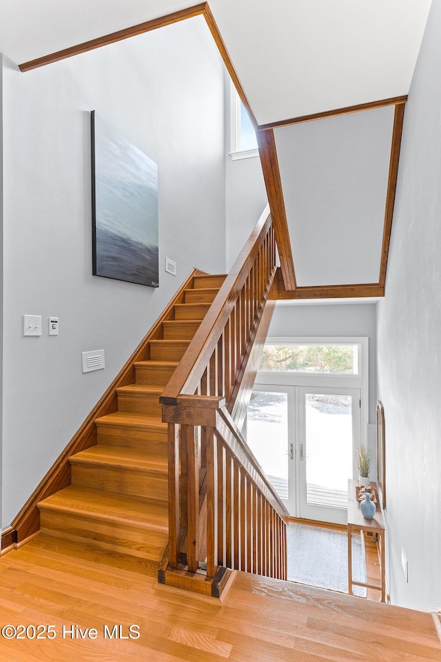 stairs featuring french doors and wood finished floors