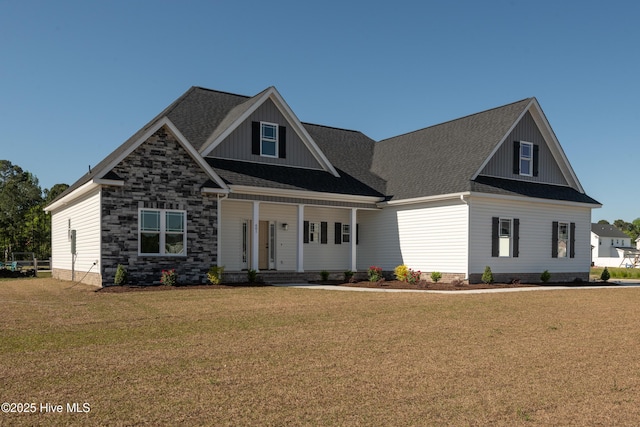 view of front facade with a porch, board and batten siding, a shingled roof, and a front yard