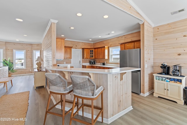 6621 W Beach Dr, Oak Island, NC 28465 - kitchen with freestanding refrigerator, wooden walls, light wood-type flooring, ornamental molding, and recessed lighting