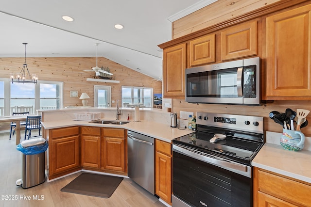 6621 W Beach Dr, Oak Island, NC 28465 - kitchen with appliances with stainless steel finishes, a sink, vaulted ceiling, a peninsula, and healthy amount of natural light