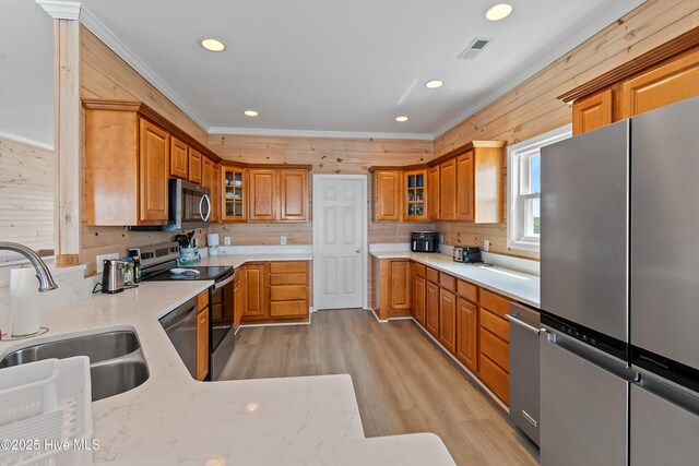 6621 W Beach Dr, Oak Island, NC 28465 - kitchen with appliances with stainless steel finishes, a sink, ornamental molding, light wood finished floors, and recessed lighting