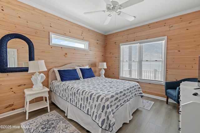 6621 W Beach Dr, Oak Island, NC 28465 - bedroom with crown molding, wooden walls, wood finished floors, a ceiling fan, and baseboards