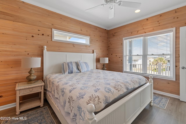 6621 W Beach Dr, Oak Island, NC 28465 - bedroom featuring wood finished floors, baseboards, crown molding, wood walls, and a ceiling fan