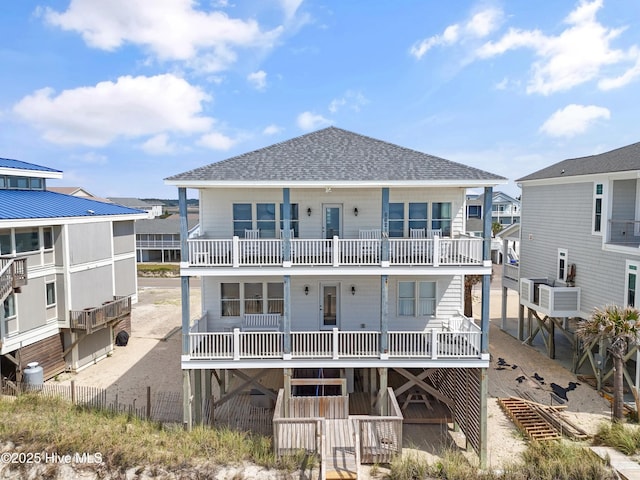 6621 W Beach Dr, Oak Island, NC 28465 - rear view of property with a shingled roof and a balcony
