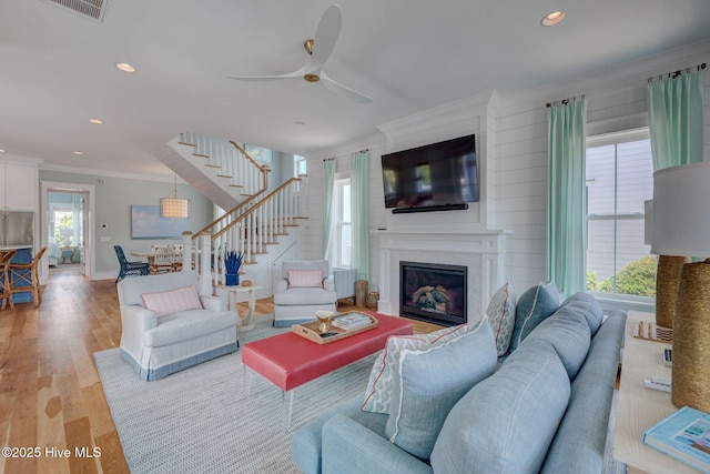801 Federal Rd, Bald Head Island, NC 28461 - living area with stairs, ornamental molding, a glass covered fireplace, ceiling fan, and light wood finished floors