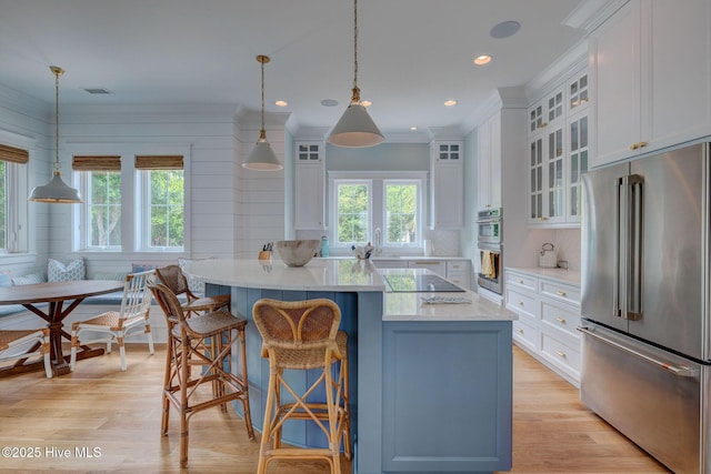 801 Federal Rd, Bald Head Island, NC 28461 - kitchen featuring appliances with stainless steel finishes, white cabinetry, a kitchen island, light wood-type flooring, and crown molding