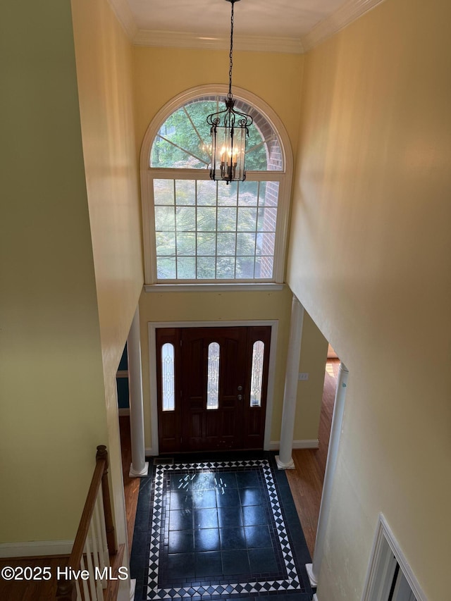 2602 Linden Ln NW, Wilson, NC 27896 - entryway featuring inlaid floor details, a chandelier, a towering ceiling, baseboards, and crown molding