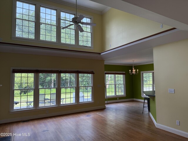 2602 Linden Ln NW, Wilson, NC 27896 - unfurnished living room featuring ornamental molding, a chandelier, baseboards, wood finished floors, and ceiling fan