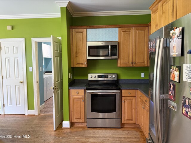 2602 Linden Ln NW, Wilson, NC 27896 - kitchen with stainless steel appliances, dark countertops, ornamental molding, light wood finished floors, and baseboards