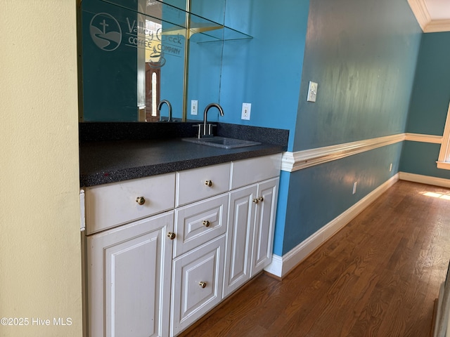 2602 Linden Ln NW, Wilson, NC 27896 - bar area featuring a sink, dark wood-style flooring, baseboards, and crown molding